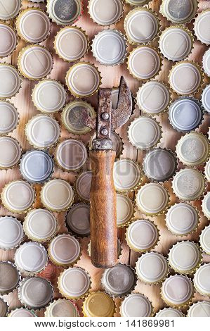 bottle opener on a background of beer caps top view