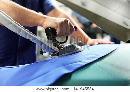 Ironing professional. Presser in sewing clothes pressed.
