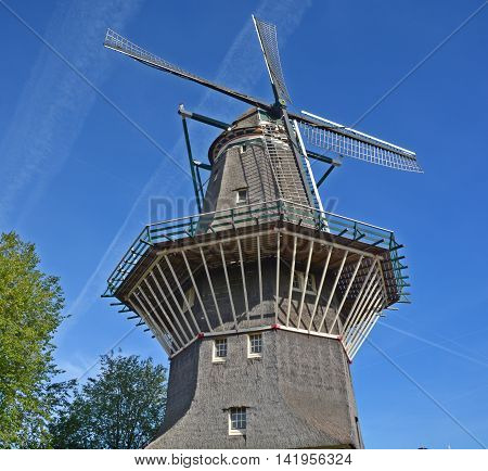 AMSTERDAM NETHERLANDS OCTOBER 01 2015: Nestled on the water at Zeeburgerdijk swings the huge blades of Amsterdam only windmill. But next door is the organic craft brew centre, Brouwerij 't IJ