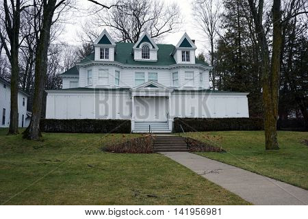 WEQUETONSING, MICHIGAN / UNITED STATES - DECEMBER 22, 2015: A large white home, christened Cedarmere, on Beach Road in Wequetonsing, is boarded up for the winter weather.