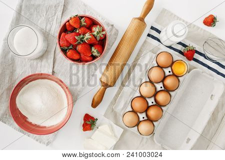 Raw Ingredients For Cooking Strawberry Pie Or Cake On White Background  (eggs, Flour, Milk, Sugar, S