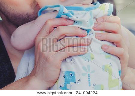 Close-up To Hands  Of Father Embracing And Kissing His Sweet Adorable Baby.