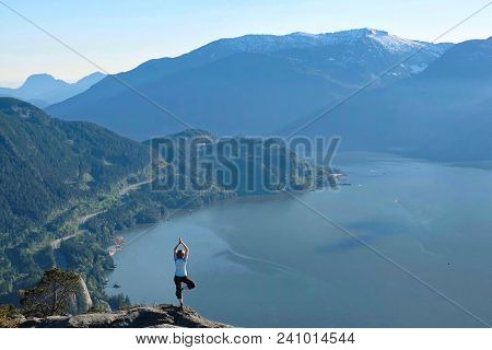 Mindfulness And Inner Peace. Outdoor Yoga Retreat. Woman In Yoga Pose On Rock Above Sea. Whister. Br