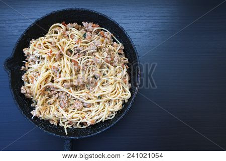 Appetizing Spaghetti In An Old Frying Pan With Bolognese Sauce On A Dark Background Close Up And Cop