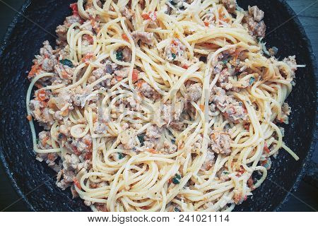 Appetizing Spaghetti In An Old Frying Pan With Bolognese Sauce On A Dark Background Close Up