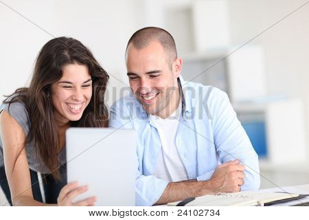 Workmates ที่ทำงานในโครงการด้วยแท็บเล็ตอิเล็กทรอนิกส์