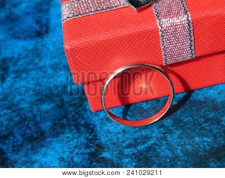 Wedding Ring And Gift Box On Blue Background. Marriage Proposal Concept