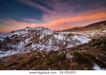 The Peak Of The Snow On The Mountains At Sunset Under A Colorful Sky