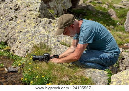 Hiker With Camera Taking Picture Of A Small Stream