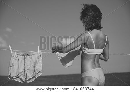 Girl Or Housewife Hang Underwear Shorts And Pants On Clothespin And Clothesline Rope In Colorful Lig