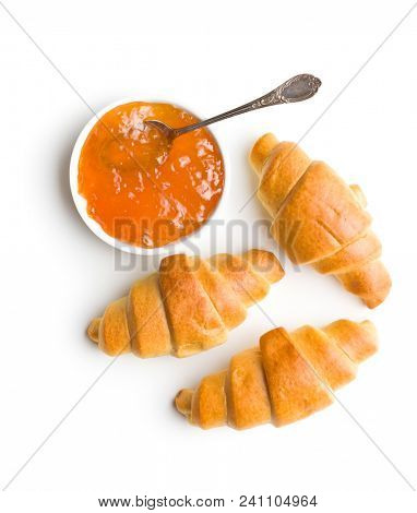 Sweet buttery croissants and fruity jam isolated on white background. Top view.