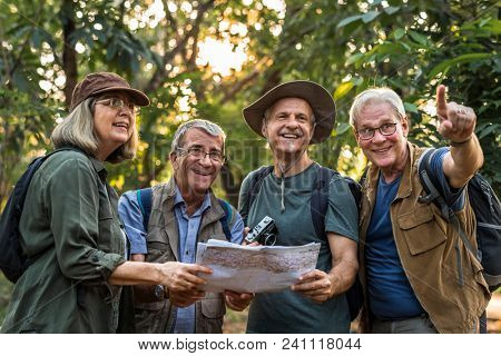 Group of senior trekkers checking a map for direction