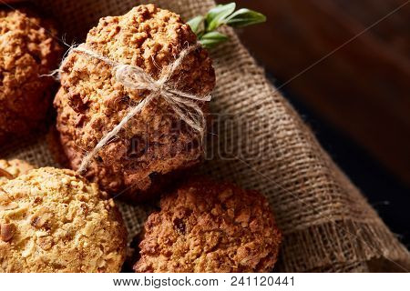 Conceptual Composition With Assortment Of Cookies On Burlap Napkin Covering A Wooden Barrel Over Rus