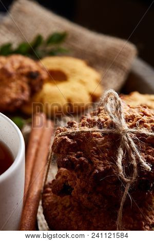 Conceptual Composition With Assortment Of Cookies, Cinnamon Sticks Bunch And Dried Oranges On Burlap