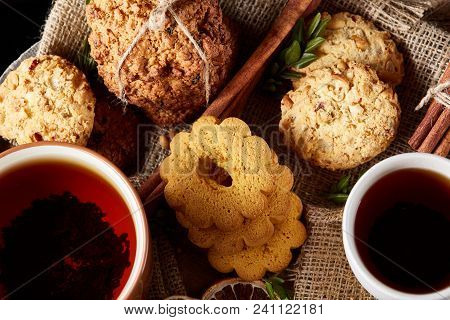 Cookies With Cinnamon And Two Cups Of Tea On A Burlap Napkin, Selective Focus, Close-up, Top View. D