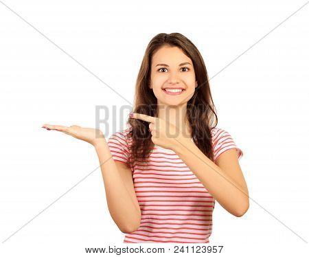 Smiling And Happy Woman, Looking To You Camera Ahead And Showing With Index Finger Hand To The Left 