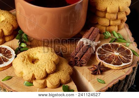 Christmas Concept With A Cup Of Hot Tea, A Large Set Of Cookies, Cinnamon Sticks Bunch, A Couple Of 