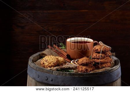 Conceptual Festive Composition With A Cup Of Hot Tea, A Large Set Of Cookies, Cinnamon Sticks Bunch 