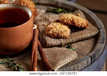 Conceptual Festive Composition With A Cup Of Hot Tea, A Large Set Of Cookies, Cinnamon Sticks Bunch 