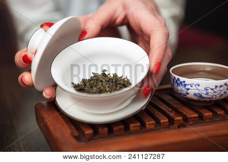 Cropped shot of woman holding chawan with green oolong.