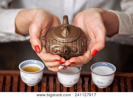 Cropped Shot Of Woman Pouring Tea In Traditional Chinese Teaware.