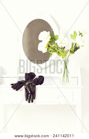 Black Leather Glovers Lying Near Transparent Vase With Roses On Vintage Female Boudoir With Console 