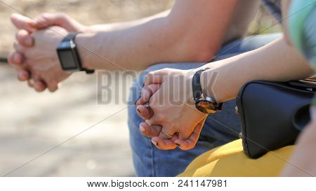 Hands Of A Girl And A Guy With A Clock .