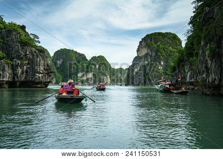 Halong Bay In Vietnam, Unesco World Heritage Site, With Tourist Rowing Boats