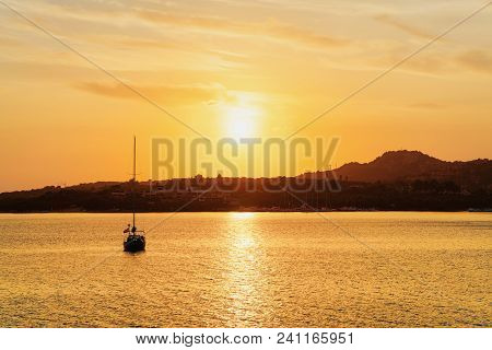 Sunrise With Boat At Costa Smeralda In Mediterranean Sea, Sardinia, In Italy