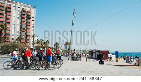 BARCELONA, SPAIN - APRIL 27, 2018: A group of tourists taking part in a cycling tour in the seafront of La Barceloneta in Barcelona, Spain