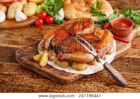 Fried Chicken With A Garnish Of Baked Young Potatoes. Chicken Tobacco And An Exquisite Fork. Appetiz