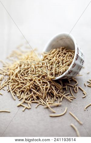Popular Indian & Gujarati Dish Aloo Sev Or Potato Sev Or Mint Flavored Sev In A Bowl On A Brown Surf
