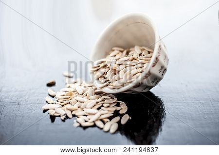 Edible Dried Raw Organic Seeds Of Musk Melon Or Cantaloupe Or Tati Or Honeydew On A Wooden Surface.