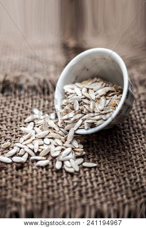 Edible Dried Raw Organic Seeds Of Musk Melon Or Cantaloupe Or Tati Or Honeydew On A Wooden Surface.