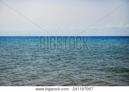 The Blue Ocean With Dull Clouds On A Lovely Sunny Day