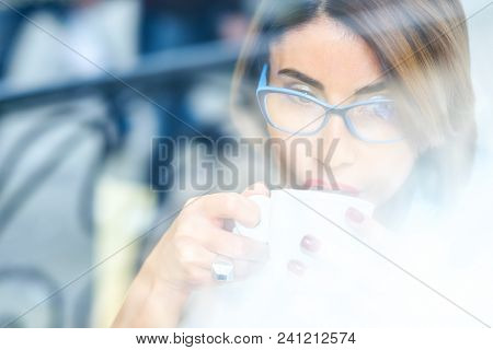Happy Girl In White Shirt Drinking Coffee While Sitting On Windowsill In Morning