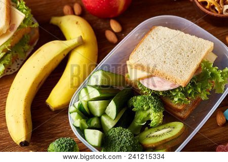 Concept Of School Lunch Break With Healthy Lunch Box Full Of Sandwiches, Banana, Apples And School S