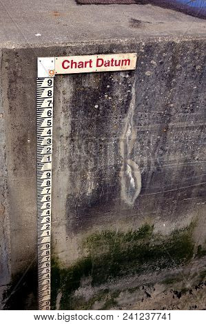 Tide Gauge Or Tide Staff On A Harbour Wall, Showing Chart Datum, Used By Boats To Determine Water De
