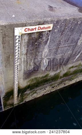 Tide Gauge Or Tide Staff On A Harbour Wall, Showing Chart Datum, Used By Boats To Determine Water De