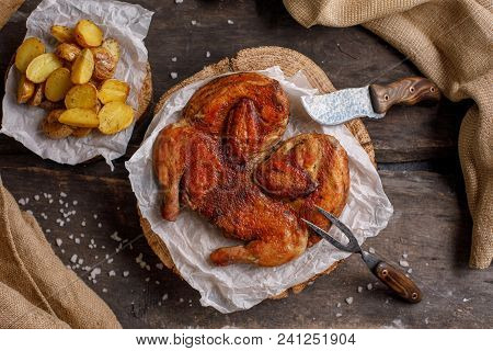 Chicken Of Tobacco And Potato Garnish On Wooden Spilah.rustic.still Life With Original Cutlery.
