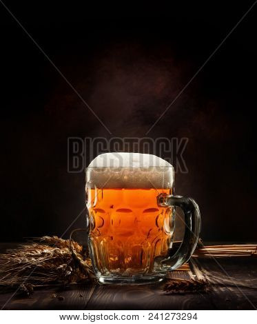 Beer In Mug And Wheet On Wooden Table And Black Background