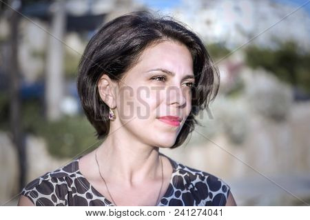 Brunette Girl On The Coast Of The Mediterranean Sea, Looks Into The Distance.