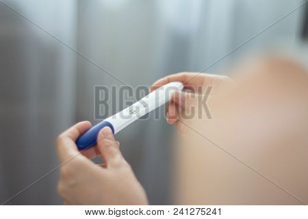 Young Woman With Pregnancy Test In Hands. The Test Shows A Positive Result