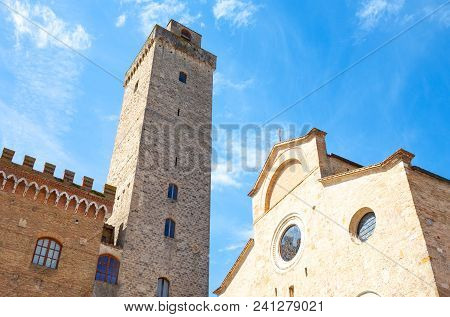 San Giminiano, Italy , Upward View Of The Cathedral Facade And A Medieval Tower In Duomo Square