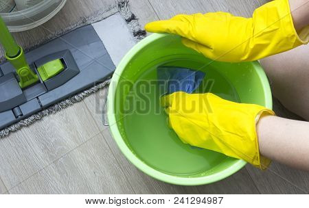 A Girl In Yellow Gloves Wets A Rag In A Bucket, Cleaning Equipment