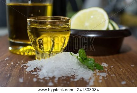 Kitchen Still Life With Sea Salt, Coriander, Olive Oil In Shot Glass And Slices Of Lime In Small Dar