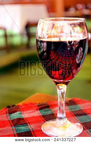 Red Wine In Wineglass On The Table With A Tablecloth In A Restaurant. Loneliness. Alcoholism.