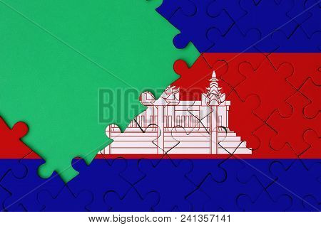Cambodia Flag  Is Depicted On A Completed Jigsaw Puzzle With Free Green Copy Space On The Left Side.