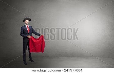 Businessman standing with red toreador cloth in his hand in an empty room