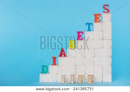 Word Diabetes Of Colored Letters And Life Gray Letters On Ladder Refined Sugar, Blue Background. Сon